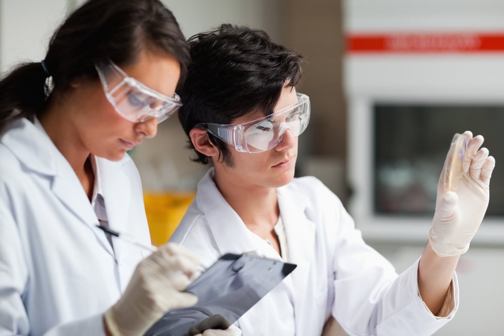 Concentrate science students looking at Petri dish in a laboratory-2